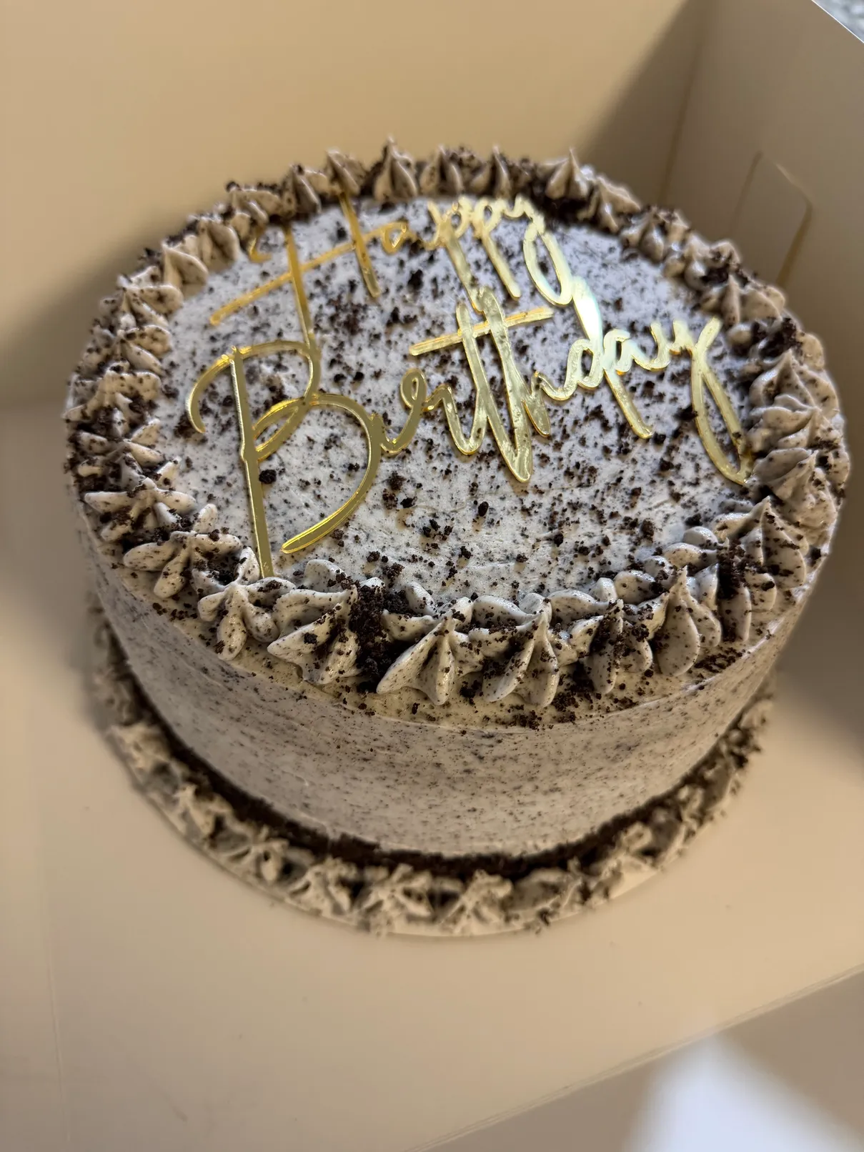 Cookies-and-cream birthday cake with gold Happy Birthday topper